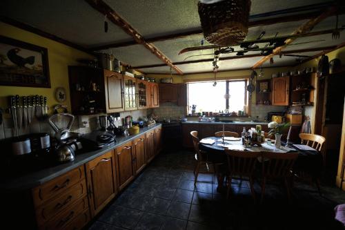 a kitchen with a stove, sink, and cabinets at Sandwick Bay Guest House in Stornoway