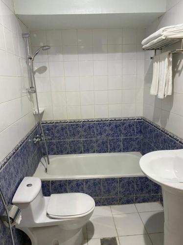 a bathroom with a toilet and a tub and a sink at ديوان اليمامة للشقق المخدومة in Taif