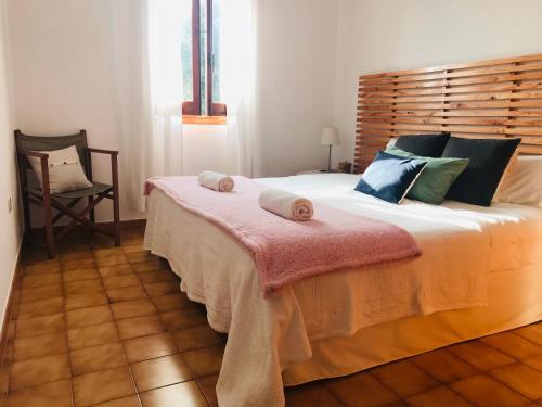 a bedroom with a large bed with a wooden headboard at Casa 3 dormitorios Cala Galdana in Cala Galdana