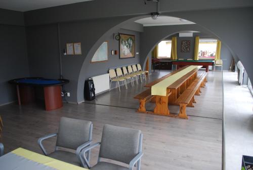 una sala da pranzo con tavolo, sedie e arco di Casa Napsugár Panzió ad Apostag