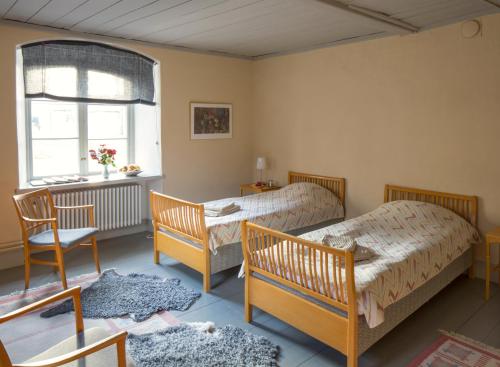 1 dormitorio con 2 camas y ventana en Biskops Arnö, en Biskops Arnö