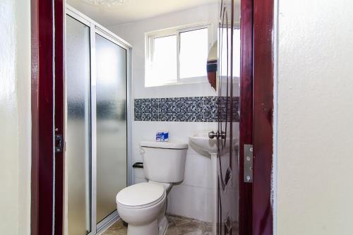 een badkamer met een toilet, een wastafel en een raam bij Awesome Studio-apartment For 2 Near Las Americas Airport and Colonial Zone in La Viva