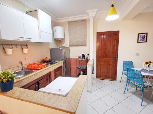 eine Küche mit einem Waschbecken und einem Tisch in der Unterkunft Reta-Inn Martil Beach in Martil