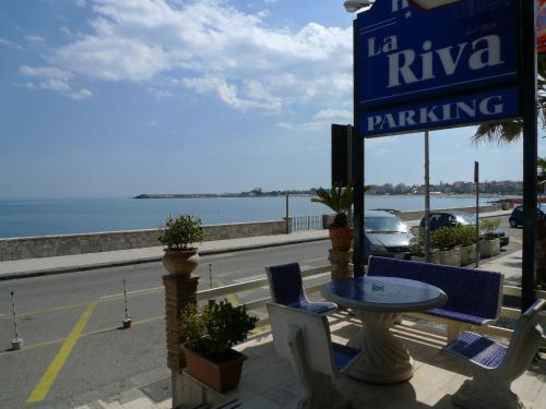 a patio with a table and chairs and a parking sign at Hotel La Riva in Giardini Naxos