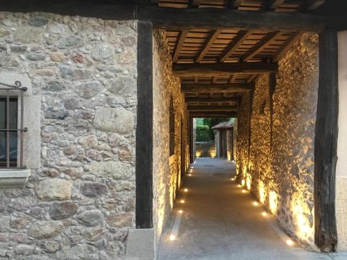 un couloir d'un bâtiment en pierre avec des lumières sur celui-ci dans l'établissement Aura del Jerte, à Jerte