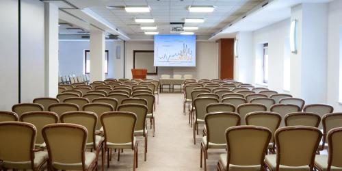 an empty lecture hall with chairs and a screen at Hotel Belweder in Ustroń