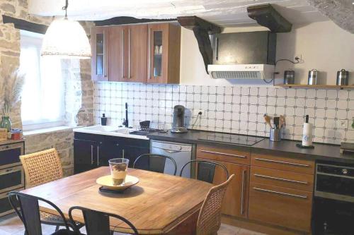 a kitchen with a wooden table and a table and chairs at Gîte Le Lau-Kal in Septfonds