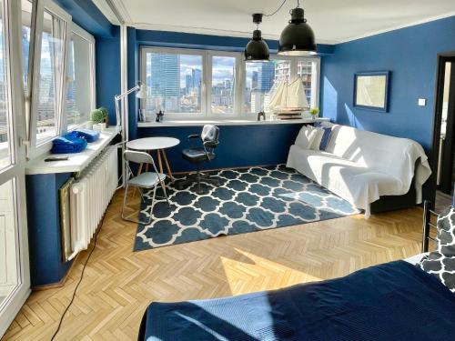 um quarto com paredes azuis e uma cama e um tapete em Super Apartament BLUE Ścisłe Centrum Dwie Linie Metra Netflix WiFi 300 Mbs Panorama Miasta em Varsóvia
