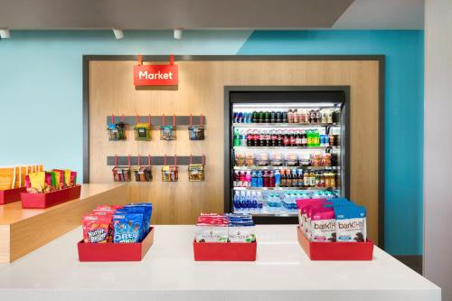 a store with a counter with a drink refrigerator at Avid Hotel Cedar Rapids South - Arpt Area by IHG in Cedar Rapids