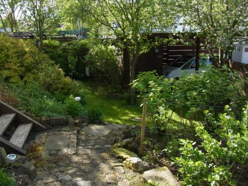 a garden with a fence and a stone path at Gästehaus VillaVerde in Kelberg