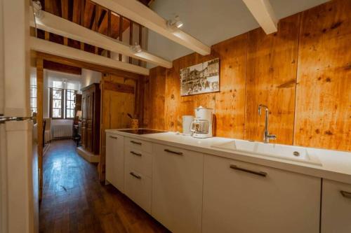 - une cuisine avec des murs en bois et un comptoir blanc dans l'établissement Le Rousseau, à Annecy