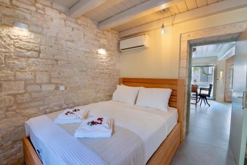 a bedroom with a bed and a stone wall at Lakka Stone House 0 in Gaios