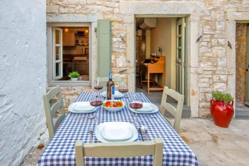 a table with a blue and white checkered table cloth at Lakka Stone House 0 in Gaios
