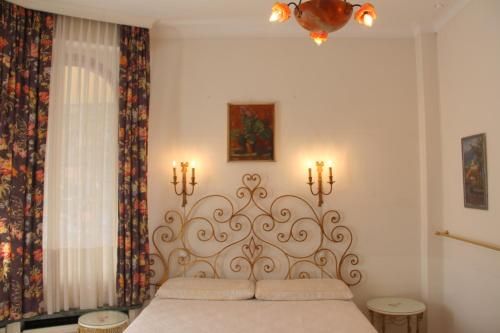 a bedroom with a bed with two candles on the wall at Barony Le Pergole holiday apartments Lugano in Lugano