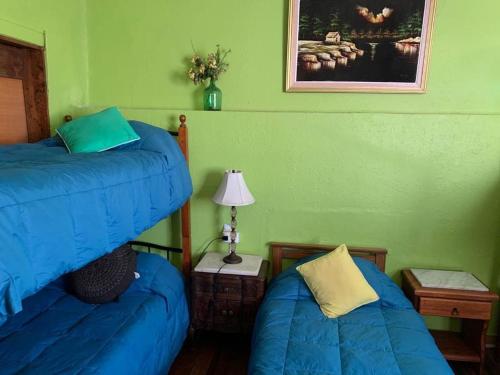 a bedroom with two beds and a lamp on a table at Residencial Campo Verde in La Serena