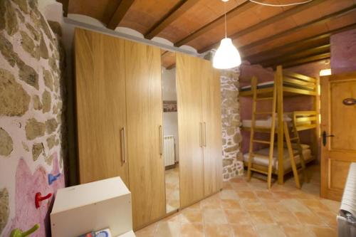 una habitación con armarios de madera y una habitación con literas en Cal Peretes - Apartamento de montaña en el Cadí, en Arsèguel