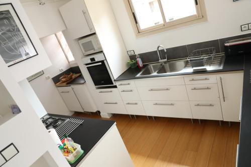 a kitchen with white cabinets and a black counter top at Collioure Centre Ville, Calme, Clim in Collioure