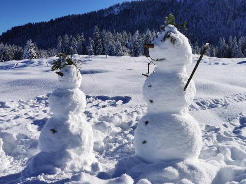 two snowmen are standing in the snow at Menkenhof in Reit im Winkl