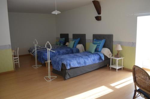 a bedroom with two beds with blue pillows at Logis de Chezelles in Sidiailles