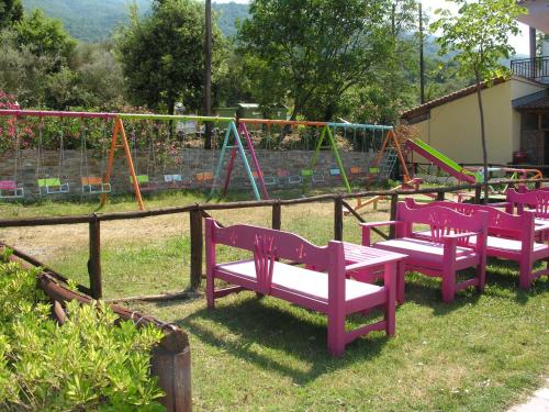 a group of purple benches in a playground at Hotel Vlassis in Stómion