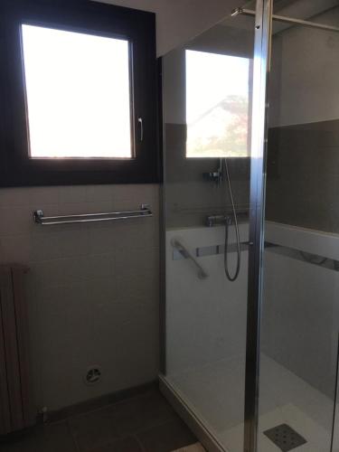 y baño con ducha acristalada y ventana. en Villa Le Rocher, en Villar-Saint-Pancrace
