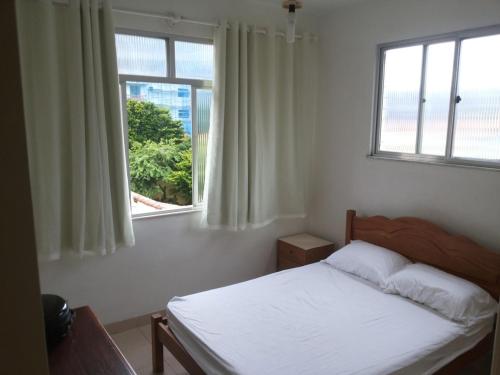 Apartamento Cabo Frio في كابو فريو: غرفة نوم بسرير ابيض ونافذة