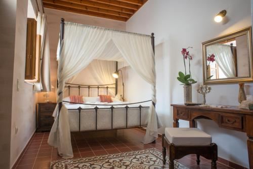 1 dormitorio con cama con dosel, mesa y piano en Villa Amalia, en Lindos