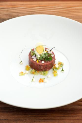 a piece of meat on a white plate on a table at Hotel Tenne in Reckingen - Gluringen