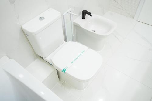 a white bathroom with a toilet and a sink at SHIMresidence LUXURY in Rădăuţi