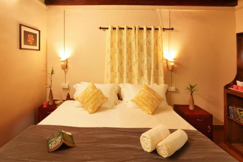 a bedroom with a bed with yellow and white pillows at Zostel Homes Wayanad, Thirunelly in Wayanad