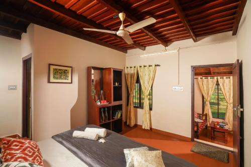 a bedroom with a bed and a ceiling fan at Zostel Homes Wayanad, Thirunelly in Wayanad