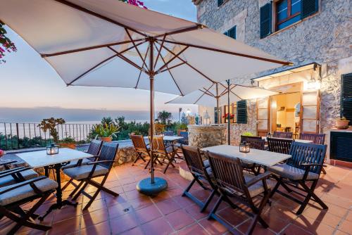 a patio with tables and chairs and an umbrella at Hotel D´Interior Ca Mado Paula in Banyalbufar