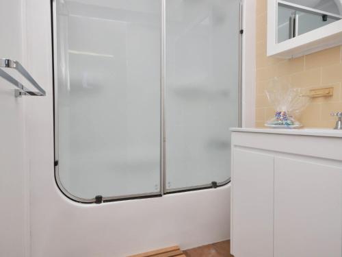 a shower with a glass door in a bathroom at The Studio on the Lake at Fishing Point Lake Macquarie in Fishing Point