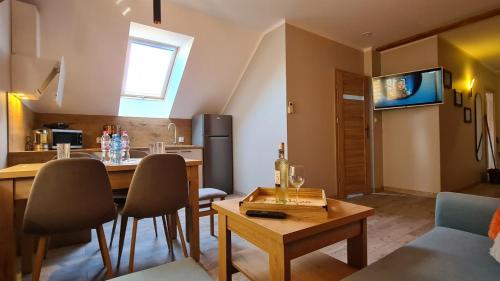 Una cocina y una sala de estar con mesa y sillas. en Apartament Komarno IV, en Jelenia Góra