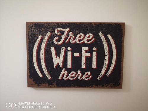 a sign on a wall with the words free wifi here at Hercules House - Il riposo degli Eroi in Ercolano