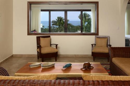 a living room with a table and chairs and a window at Casa Sayulita, MISTIKA in Sayulita
