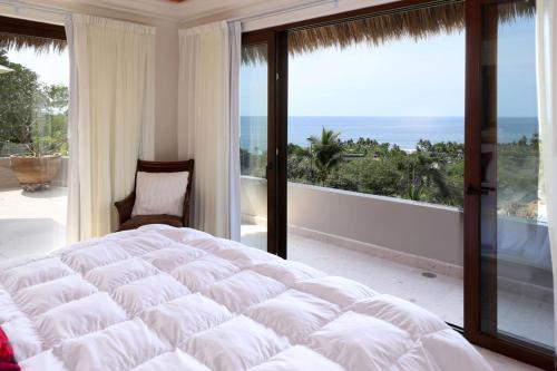 サユリタにあるCasa Sayulita, MISTIKAの大きな白いベッドとバルコニーのある寝室