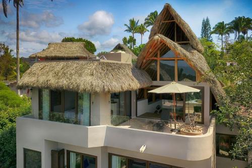 a building with a straw roof and an umbrella at Casa Sayulita, MISTIKA in Sayulita