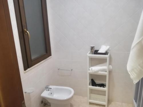 a white bathroom with a toilet and a sink at Kite Francy's house in Marsala