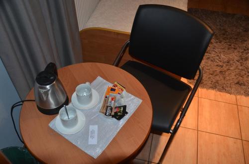 a wooden table with a black chair and a table with a coffeeucer at Marta in Okuninka