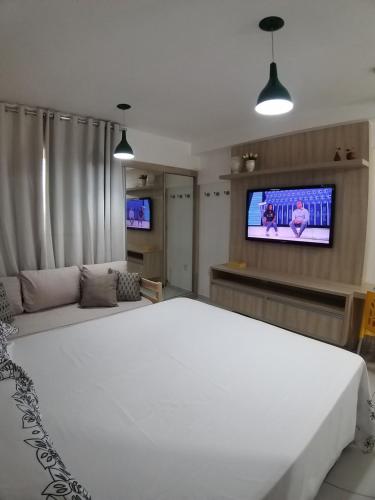 een slaapkamer met een groot wit bed en een flatscreen-tv bij Smart Residence Flat - FLAT 605 in Teresina