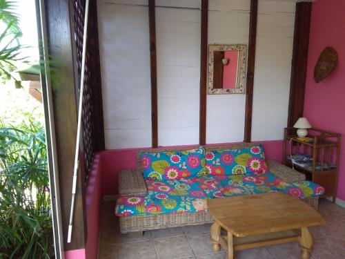 a living room with a couch and a table at Gite bagatelle classé 2 étoiles in Sainte-Rose