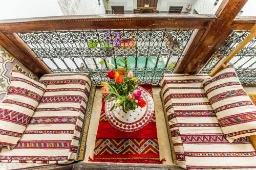 a table with a vase of flowers on top at Riad Atlas Mejbar in Marrakesh