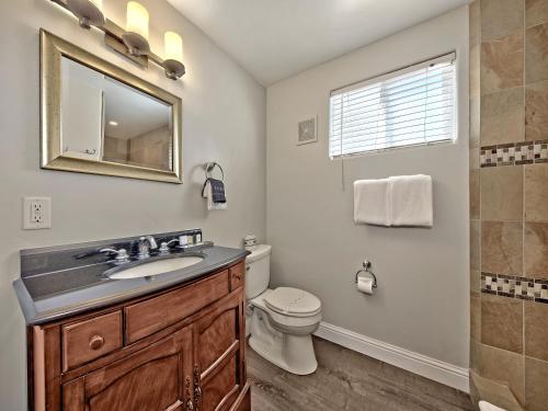a bathroom with a sink and a toilet and a mirror at Secrets Inn Lake Tahoe in South Lake Tahoe