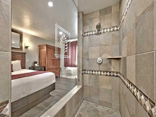 a bedroom with a bed and a walk in shower at Secrets Inn Lake Tahoe in South Lake Tahoe