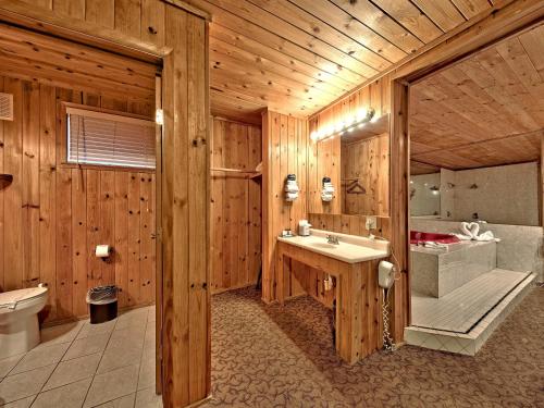 a wooden bathroom with a sink and a tub at Secrets Inn Lake Tahoe in South Lake Tahoe