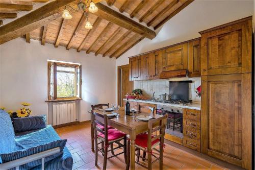 a kitchen with a wooden table and a dining room at Agriturismo La Fragola in Cignano