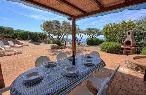 a blue table with plates and glasses on a patio at Villa Raggio Di Sole in Porto Santo Stefano