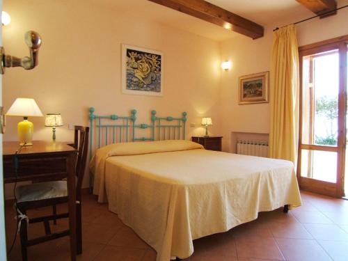 a bedroom with a bed and a table and a window at Villa Raggio Di Sole in Porto Santo Stefano