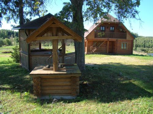 a wooden gazebo sitting next to a tree at Pumpuri in Svente
